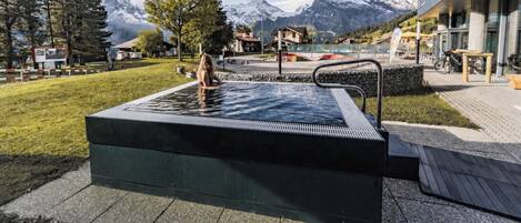 A hot tub with a view of mountains in the background.
