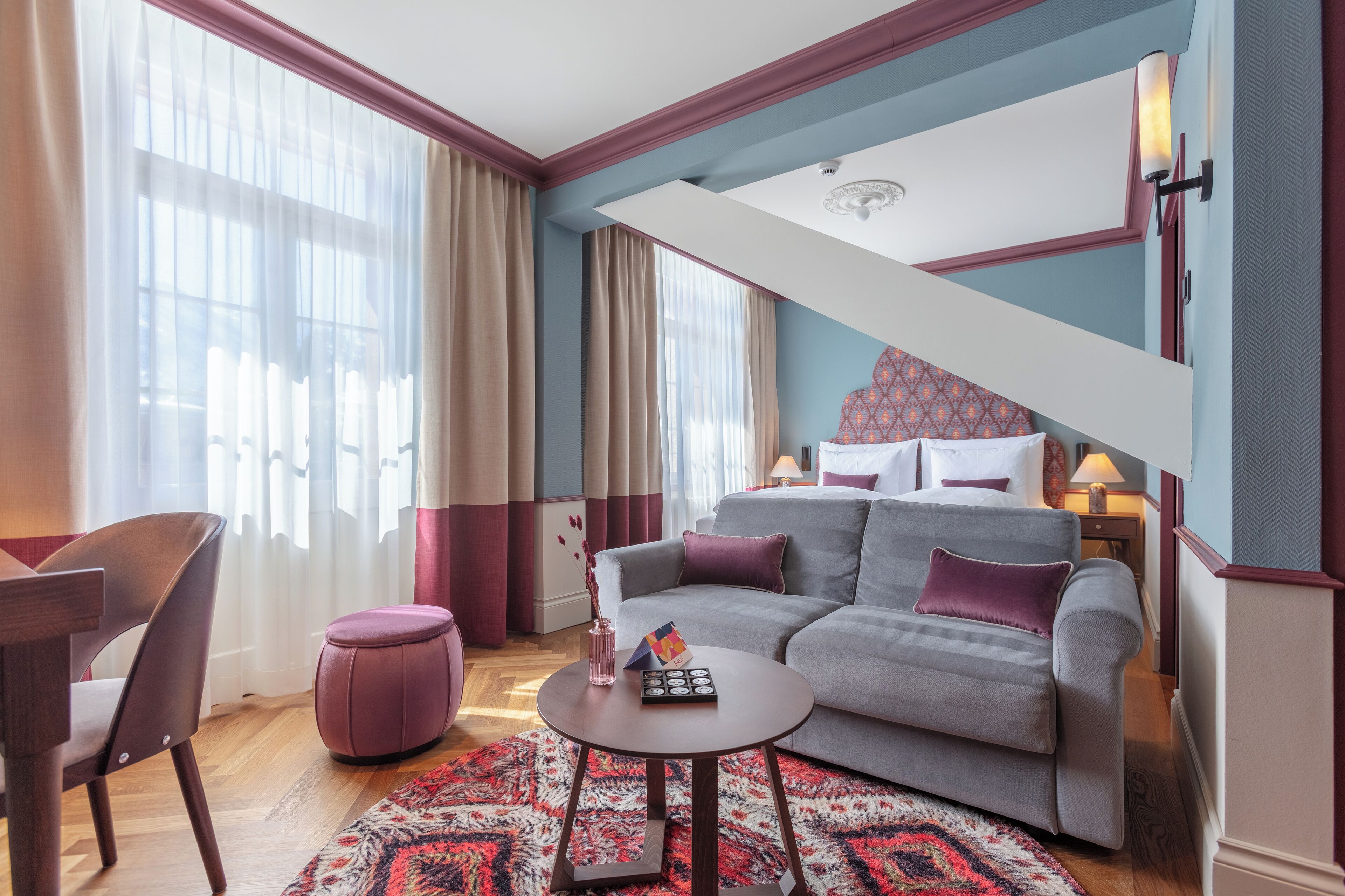 A modern living room with a grey sofa, a round coffee table, and a patterned rug.