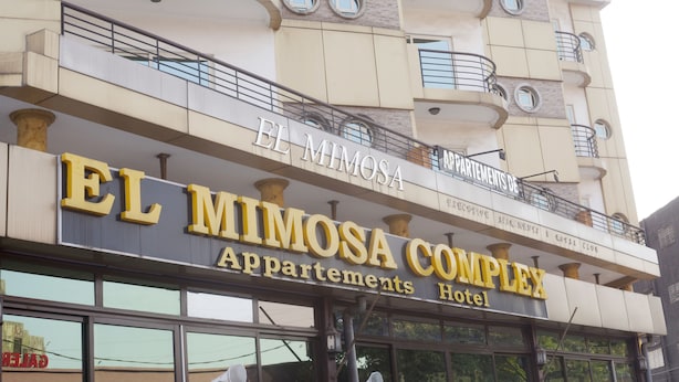 The facade of El Mimosa Complex Apartments Hotel with balconies and large windows.