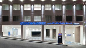 A hotel named "HOTEL PARK INN THAKHER WEST" with a modern facade, multiple entry points, and a visible parking area. - Park Inn by Radisson Makkah Thakher Algharbi (Makkah)