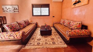 A living room with two sofas, a coffee table, and a patterned rug.