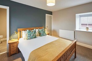 A bedroom with a large bed, a nightstand, a window, and a radiator. - Host & Stay | The Loft (Berwick-upon-Tweed)