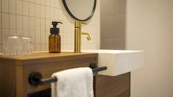 A bathroom vanity with a wooden countertop, a gold faucet, and a white sink.