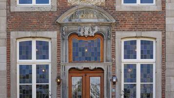 Un edificio con una entrada destacada, un escudo decorativo sobre la puerta y fachada de ladrillo.