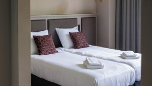 A modern hotel room with a large bed, two pillows, and a hanging light fixture. - SEPHS Hotel (Sittard)