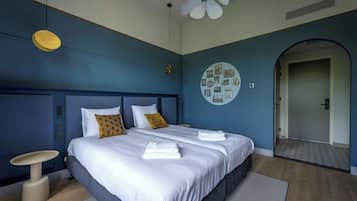 Un dormitorio moderno con una cama grande, dos mesitas de noche, un adorno circular en la pared y un ventilador de techo.