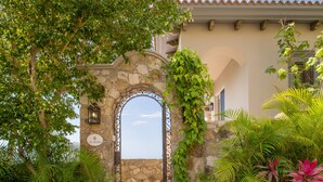 A stone archway with a number '6' sign, leading to a building with a view of the sea. - Luxurious Villas Del Mar Casita 6 with Sweeping View! (Los Cabos)