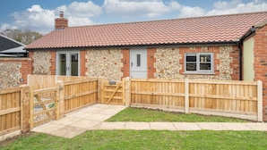 A small brick house with a tiled roof, a wooden gate, and a stone wall. - Bumblebee Cottage | East Ruston Cottages (Happisburgh)