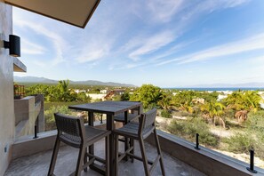Enjoy a serene coastal view from this outdoor space with a table and two chairs.