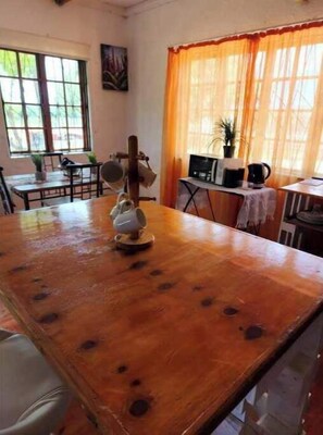 Enjoy meals at the dining table, relax by the window with a plant, and unwind with a cup of tea from the kettle.