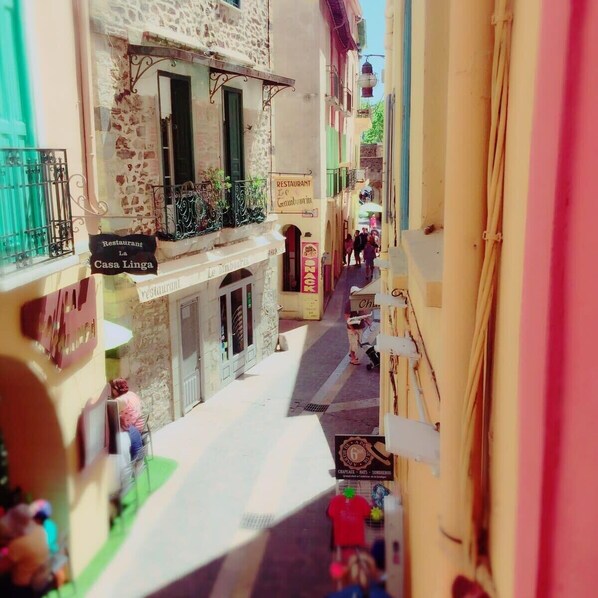 A narrow street with buildings on either side, including a restaurant named 'La Casa Linga'.