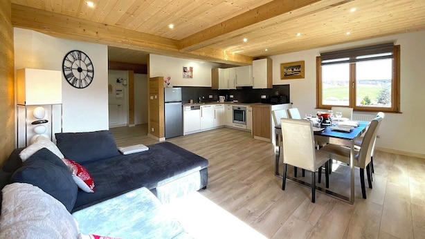 A modern interior with a living area, dining space, and kitchen. - Gite Spacieux, Cosy, Tout Confort au Pied des Pistes (Septmoncel les Molunes)