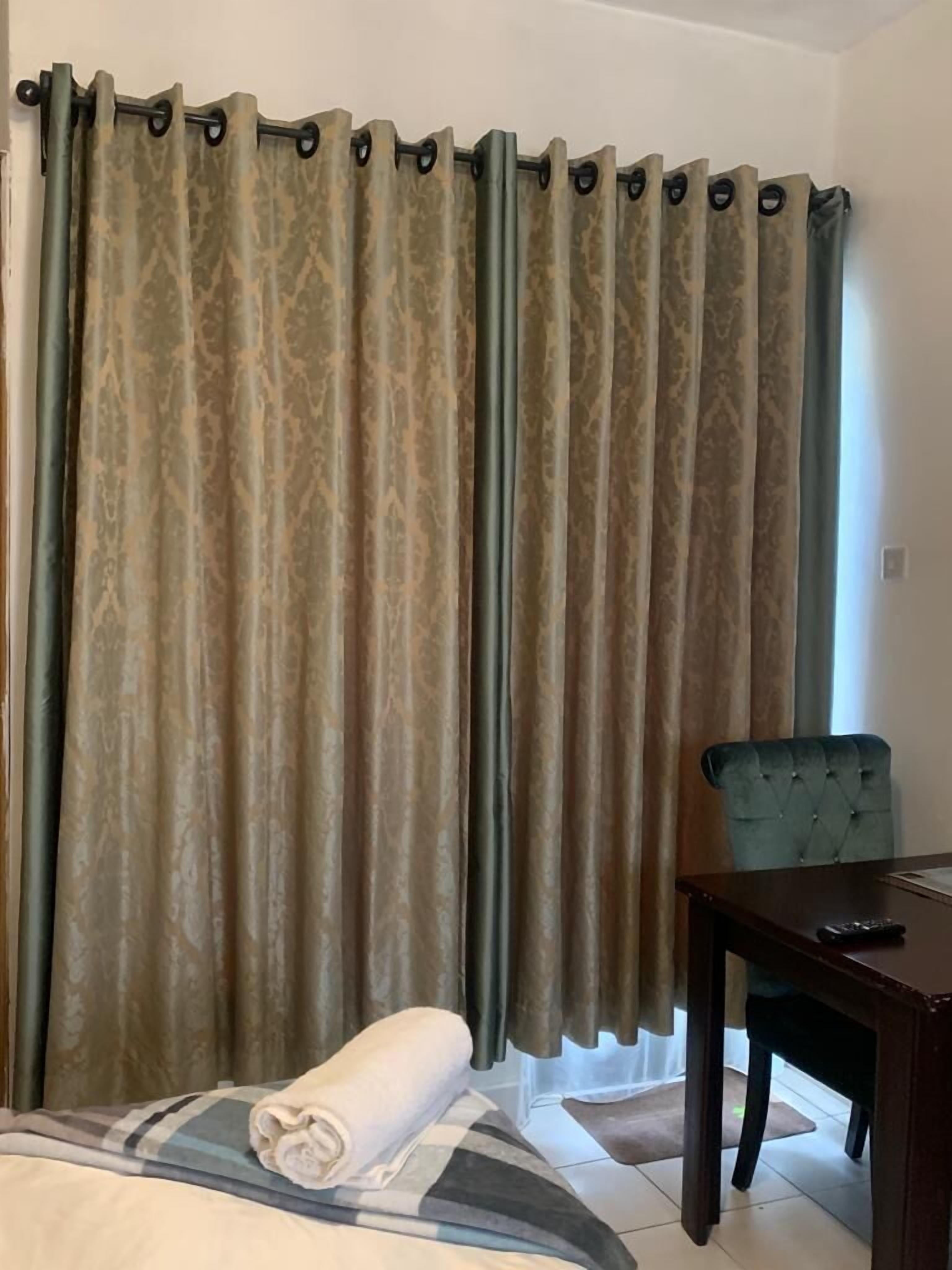 A hotel room with a bed, a chair, and a table.