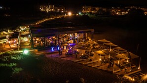 Un bar en la azotea con vistas a la ciudad de noche.