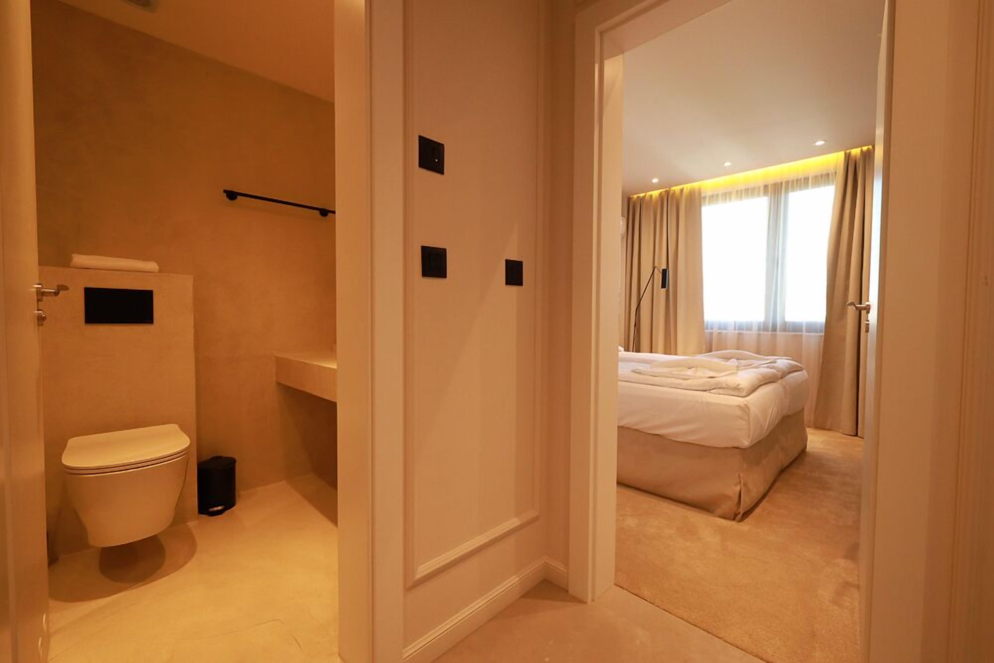 A hotel bathroom with a toilet, sink, and shower.