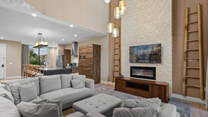 Un salon moderne avec un canapé d’angle, un téléviseur à écran plat et un meuble de rangement en bois.