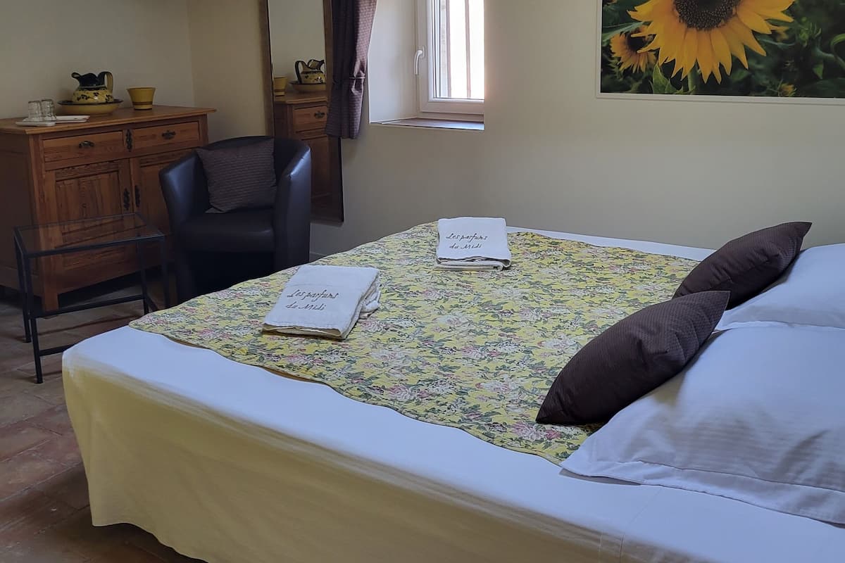 Un dormitorio con una cama, un escritorio, una silla y una ventana.