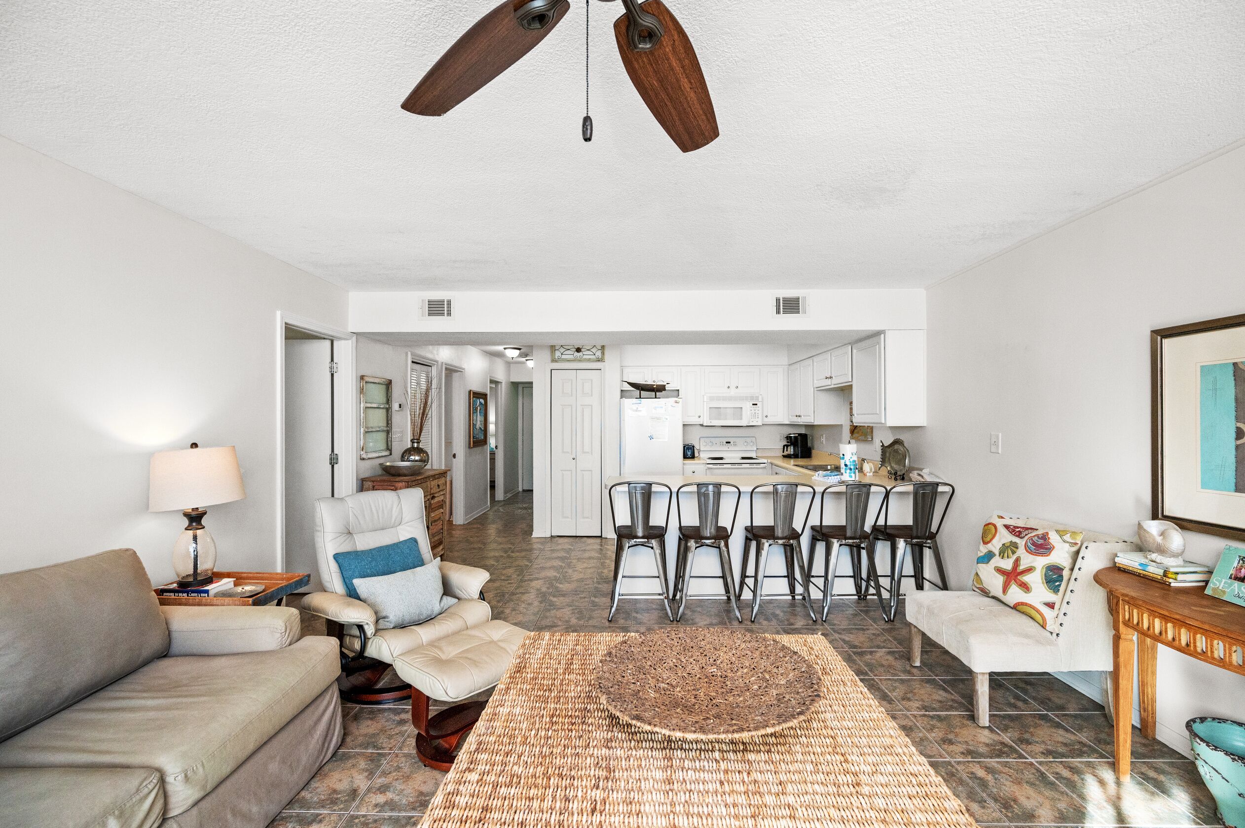 A spacious living room with a sofa, a coffee table, and a dining area with chairs.