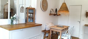 Kitchen area with a wooden countertop, white cabinet, and a table for dining and entertaining.
