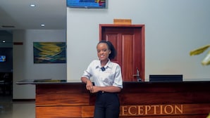 Un mostrador de recepción con detalles de madera y la palabra "RECEPTION" destacada.