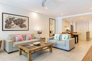 A modern living room with two sofas, a coffee table, and a dining area.