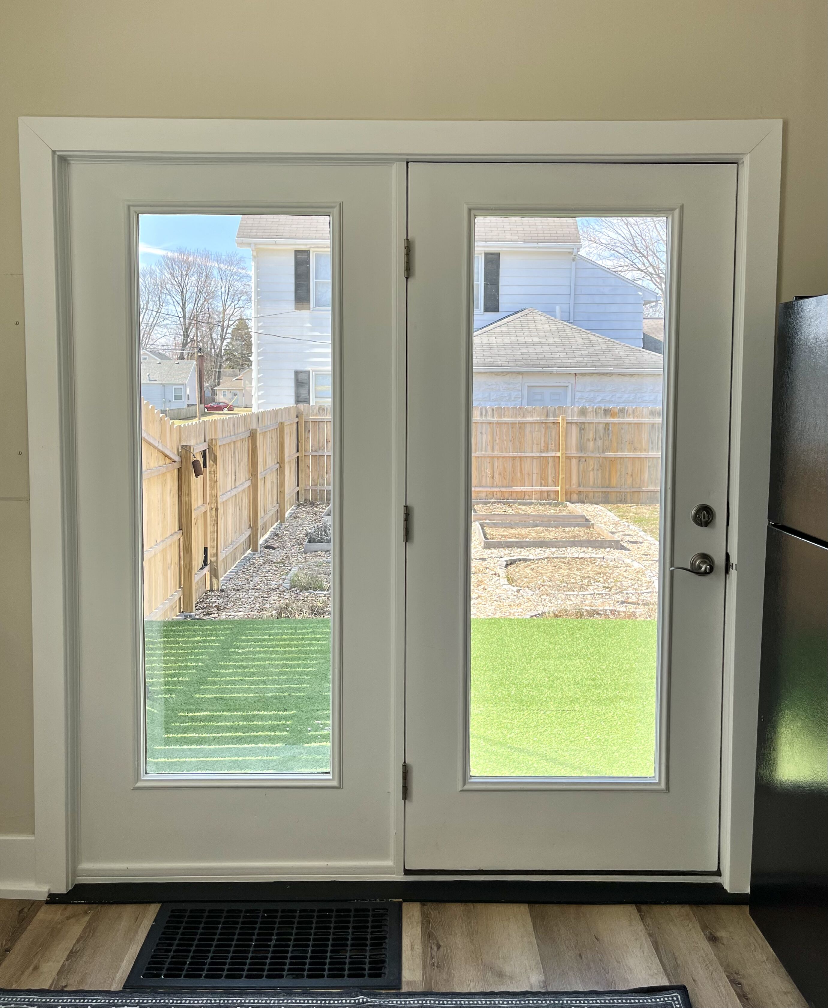 A double door with a view of a backyard.