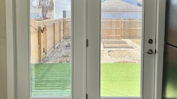 A double door with a view of a backyard.