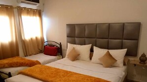 A hotel room with two beds, each with a headboard and multiple pillows. - Hôtel et Restaurant Kinan (Amersid)