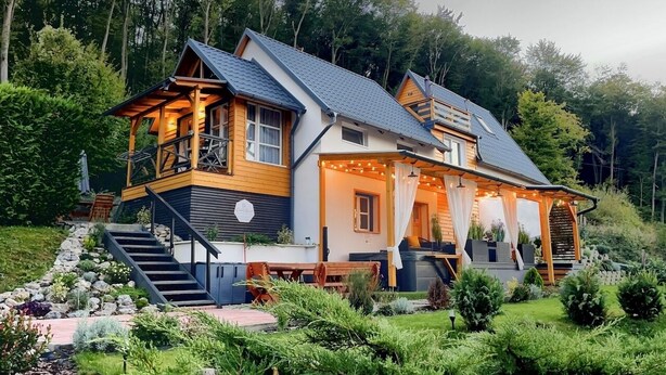 A two-story house with a balcony, a staircase, and a garden. - Calm Resort Hertelend (Magyarhertelend)