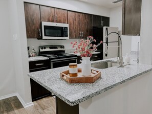 Køleskab, kaffe-/temaskine, køkkentøj/tallerkener/redskaber