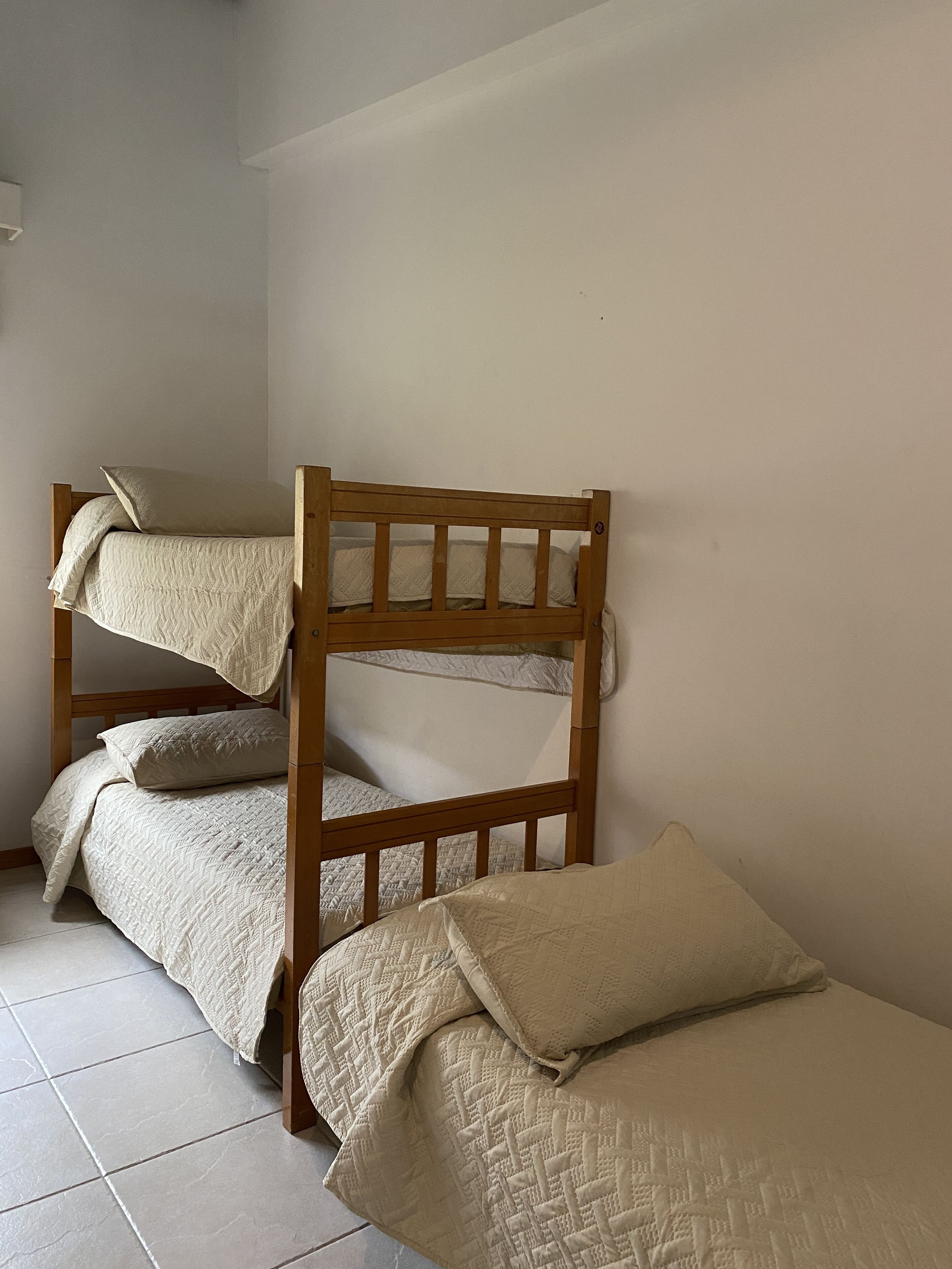 Una habitación con dos literas, cada una con una colcha acolchada y almohadas.