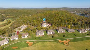 Vue aérienne d’un quartier résidentiel avec des maisons, des terrains de golf et un grand lac.