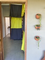 Um corredor com moldura de porta de madeira, cortina preta e amarela e chão de azulejos.