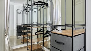 A modern walk-in closet with mirrored walls, wooden shelves, and a grey storage unit. - Modern Parisian apartment  Center of Paris (Paris)