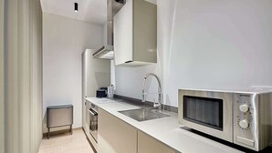 A modern kitchen with a built-in microwave, stainless steel appliances, and a sleek countertop. - Modern Parisian apartment  Center of Paris (Paris)