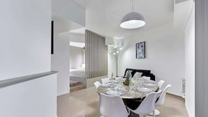 A modern dining area with a marble table, white chairs, and a pendant light. - Modern Parisian apartment  Center of Paris (Paris)
