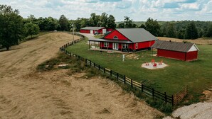 A red barn with a fenced area and a covered porch. - Red River Ranch Retreat- HOT TUB, Views, Pond- Near RRG (Frenchburg)