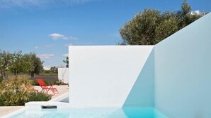 A modern outdoor swimming pool with a white wall and a clear blue sky. - Pensão Agrícola (Tavira)