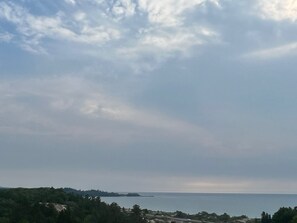 A coastal landscape with a view of the sea and a distant island.