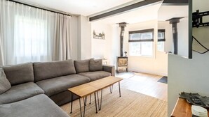 Una sala de estar moderna con un sofá seccional gris, una mesa de centro de madera y una chimenea.