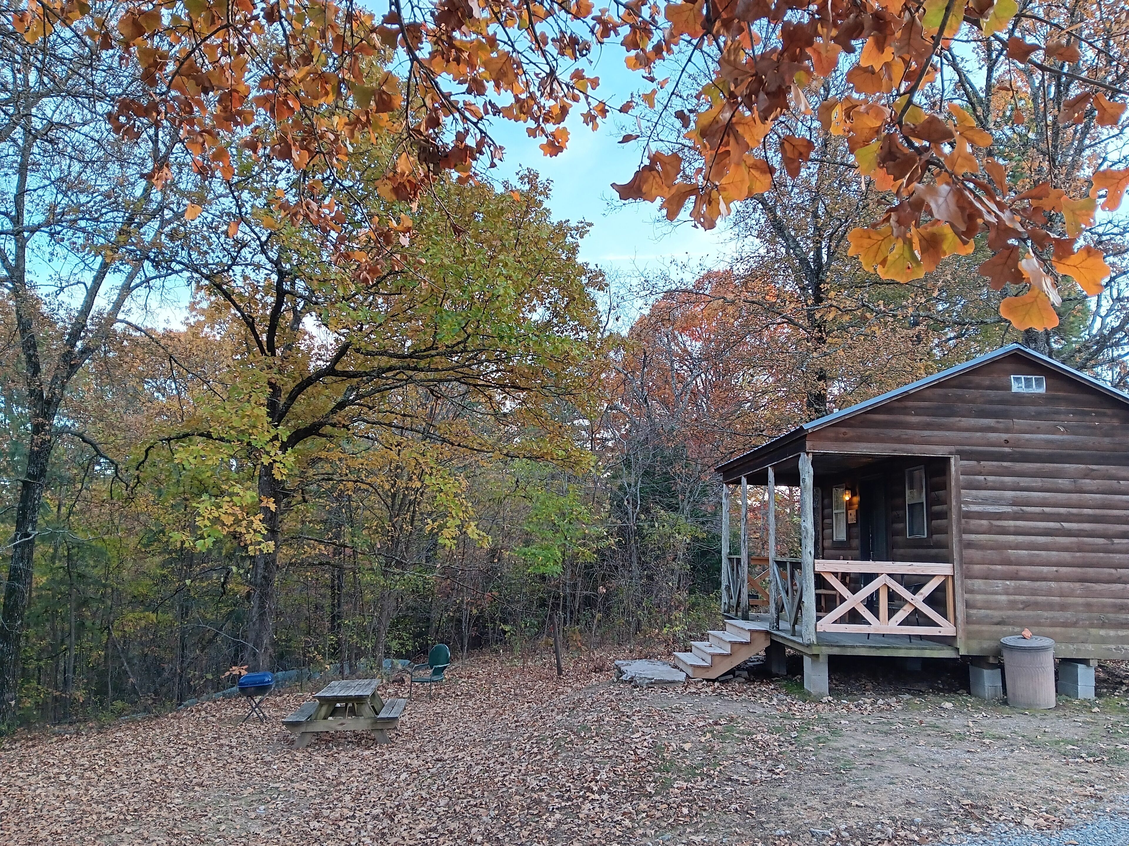 Un rustico chalet con veranda, immerso in un paesaggio autunnale.