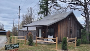Un rustico lodge in legno con tetto spiovente, un portico con ringhiere in legno e un segnale che indica un accesso privato.