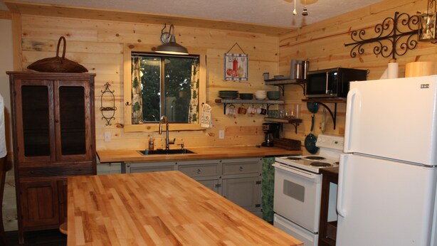 A wooden-paneled kitchen with a wooden countertop, a sink, a stove, a refrigerator, and a microwave. - Millers Landing 1 - Sleeps 6. MINUTES to Lower Buffalo River (Yellville)