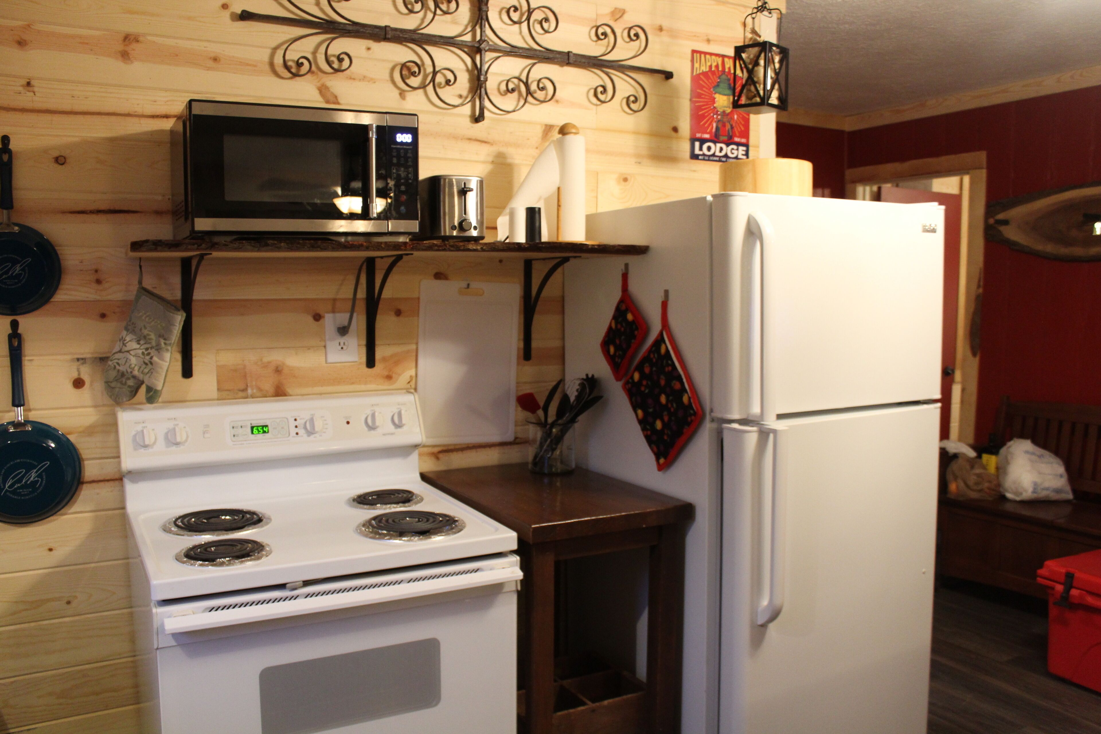 A kitchen with a stove, microwave, and refrigerator.