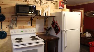 A kitchen with a stove, microwave, and refrigerator.