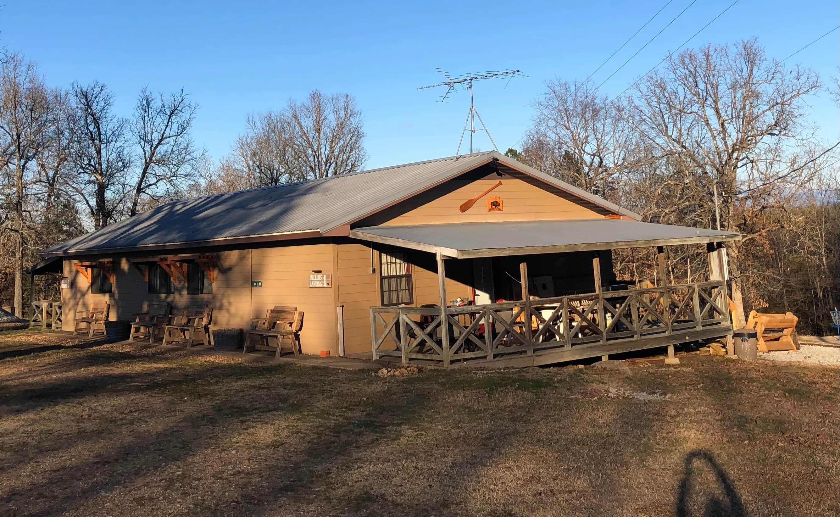 A building with a covered porch, outdoor seating, and a sign indicating a landing.