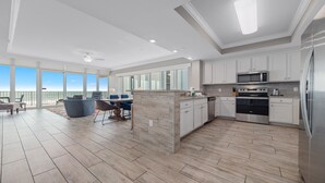 A modern kitchen with white cabinets, stainless steel appliances, and a large island. - 3rd Floor!! Parking Level!  Avoid the Elevators!! Lazy River!! (Orange Beach)