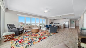 A spacious living area with a large window, a ceiling fan, and a colorful rug. - 3rd Floor!! Parking Level!  Avoid the Elevators!! Lazy River!! (Orange Beach)