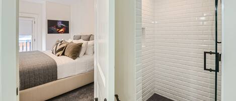 A modern bedroom with a bed, a nightstand, and a wall-mounted TV.