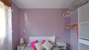 Un dormitorio con cama, mesita de noche y armario.